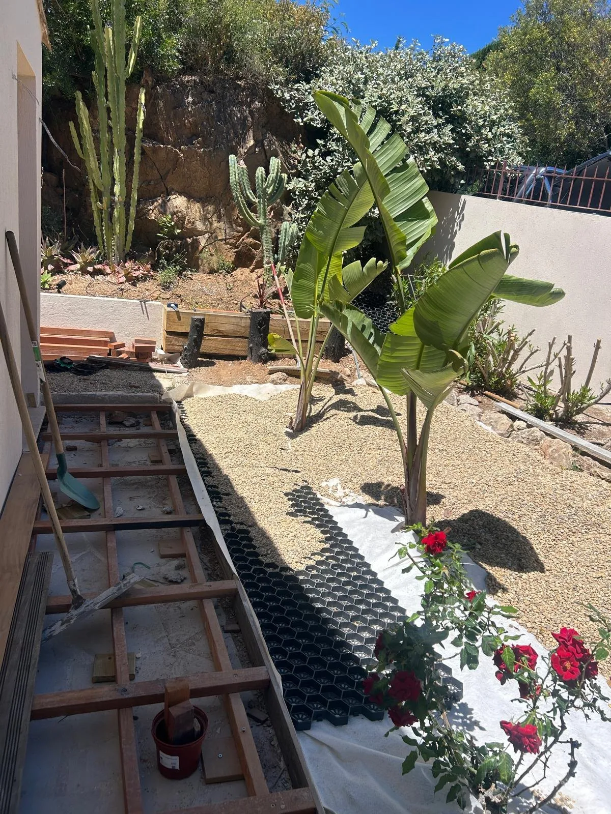 Structure de terrasse en cours de pose le long d’un massif planté